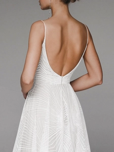Detail of white sequin backless evening gown with delicate geometric pattern and V-back