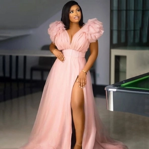 Detail of elegant V-neck tulle dress with ruffled shoulders and side slit in lotus pink