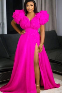 Detail of elegant bright pink maxi dress with puff sleeves, V-neck, and high side slit design