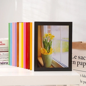 Close-up of minimalist colorful wooden photo frames stacked in various vibrant finishes