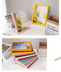Colorful minimalist wooden frames in various bright shades stacked on a white desktop