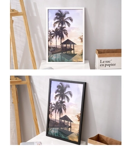 Detail of modern black and white solid wood photo frames with tropical sunset beach art