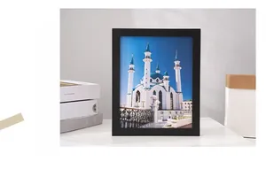 Minimalist black wooden frame with mosque art print on a modern white desktop decor