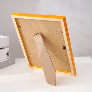 Minimalist orange pine wood picture frame showing back structure with stand and metal clips