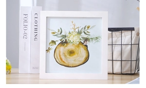 Close-up of white wooden square photo frame with Nordic watercolor tree ring art print