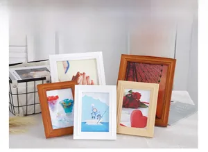 Detail of Nordic wooden photo frames in white and brown wood tones for desktop decor