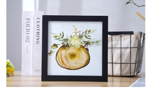 Detail of a minimalist black square photo frame with watercolor tree ring floral artwork