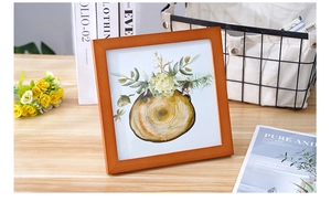 Detail of a square wooden photo frame with Nordic art in a cozy home setting