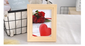 Detailed close-up of solid wood photo frame with natural grain and red rose artwork