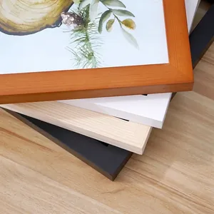 Minimalist solid wood picture frames in black, white, and natural oak stacked on wood table