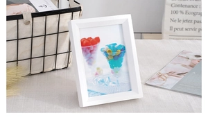 Minimalist white wooden photo frame displayed on a textured linen table in a home setting