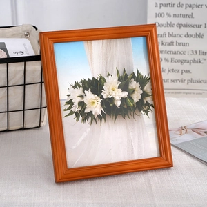 Nordic cherry wood photo frame with minimalist design and floral art on a desk