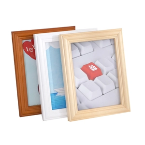 Three minimalist wooden photo frames in walnut, white, and natural wood finishes stacked