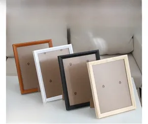 Minimalist wooden frames in walnut, white, black and natural wood displayed on a desk