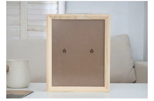 Rear view of minimalist wooden frame showing fiberboard backing and metal fasteners