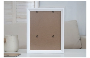 Detail view of the back structure of white wooden photo frame with brown hardboard back