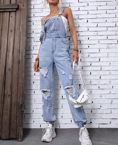 Close-up of light blue distressed denim overalls featuring ripped knee details and elastic cuffs