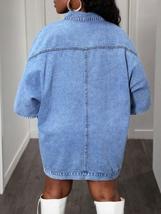 Detail of light blue oversized denim jacket back seam with heavy wash denim texture