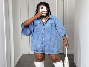 Close-up of light blue washed oversized denim vest with metal buttons and drop shoulder