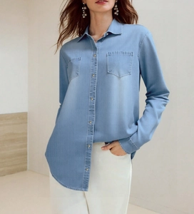 Detail of light blue denim shirt with metal buttons and classic chest pockets
