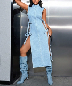 Détail d'une robe en jean bleu clair avec laçage latéral et bottes en jean assorties