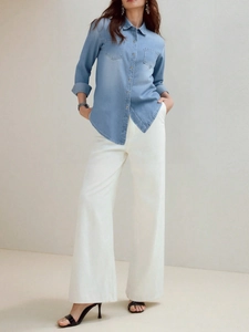 Women's light blue long sleeve denim shirt with dual pockets and white wide leg pants