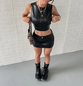 Detalle de conjunto de cuero negro de dos piezas con top corto y falda de talle alto