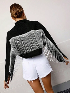Detail of elegant black denim jacket featuring long silver tassels on back and sleeves