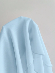 Gros plan sur un tissu en dentelle bleu clair transparent avec détails de bordure plissée