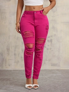 Close-up of hot pink slim fit jeans featuring ripped distressed details and metal button