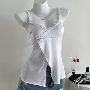 Detail of white satin camisole featuring delicate floral lace trim and asymmetric hem