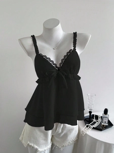 Détail du caraco noir avec bordure en dentelle délicate et nœud en satin au col en V