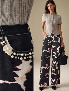 Détail du jean taille haute à motif vache avec perles et coupe jambe large chic