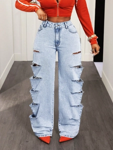 Dettaglio dei jeans a gamba larga celeste con molteplici strappi e motivi sfrangiati