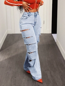 Dettaglio di jeans a gamba larga azzurri con strappi multipli e bordi sfrangiati di tendenza