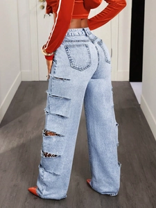 Dettaglio posteriore di jeans azzurri a vita alta e gamba larga con strappi di tendenza