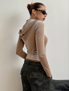Detail van de fluwelen hoodie in champagne met een zachte textuur en glanzende afwerking