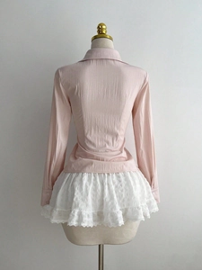 Detail view of the back of a pink pleated shirt and layered white lace tutu skirt