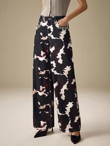 Détail du pantalon imprimé vache avec bordure en perles sur les poches avant
