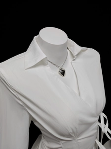 Detail of silver heart pendant necklace on white shirt with stainless steel bead chain