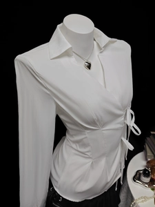 Detail of white long sleeve shirt with cross wrap front and side tie bow waist design