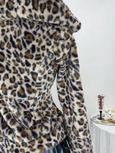 Dettaglio cappotto in ecopelliccia leopardata con morbida trama felpata e caldo cappuccio