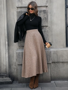 Outdoor street shot of women's A-line wool skirt in brown with a high-waist thick texture
