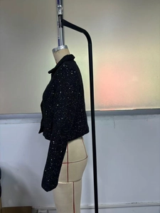 Detailed close-up of a women's black sequin short coat on a mannequin for evening wear