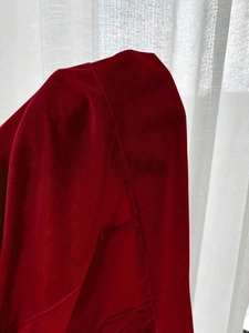 Detailopname van bordeauxrode fluwelen stof met zachte textuur en nette stiksels