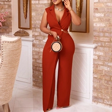 Detail of burnt orange jumpsuit showing notched lapels and gold waist chain buckle