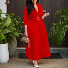 Detail of red pleated long dress with V-neckline and elegant golden buckle waist belt
