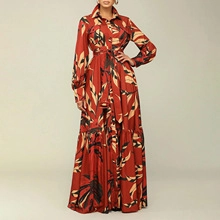 Detailed macro view of the rust-red bohemian maxi dress with brown leaf patterns