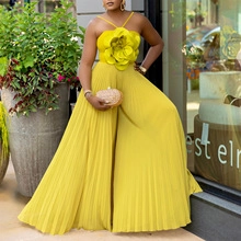 Close-up of bright yellow pleated gown featuring a large 3D handmade floral decoration