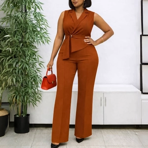Detail of rust sleeveless blazer jumpsuit with belted waist and wide leg silhouette